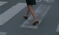 a woman is crossing a street