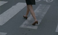 a woman is crossing a street