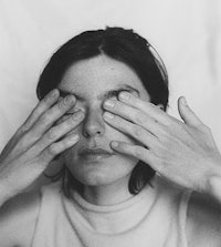 a woman covering her eyes with her hands